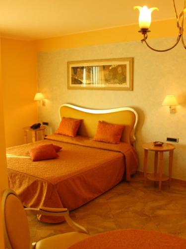 a bedroom with a large bed with orange pillows at Blu Tropical Resort in Zambrone
