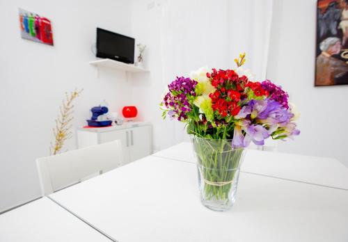 a vase filled with flowers sitting on a counter at Selenite in Capo dʼOrlando