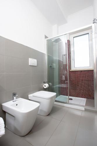 a bathroom with a toilet and a shower and a sink at Selenite in Capo dʼOrlando