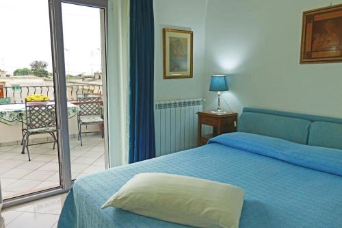 a bedroom with a blue bed and a balcony at La Ninfa Di Capri in Anacapri