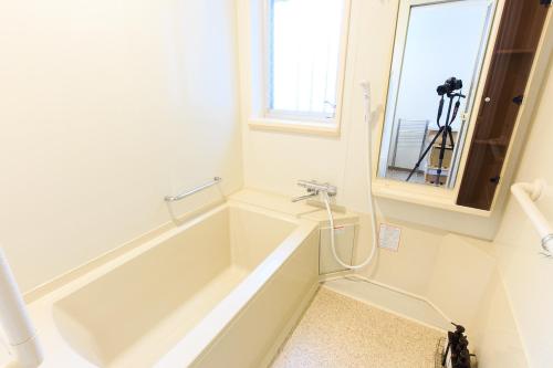 a bathroom with a bath tub with a camera at ORIGAMI STAY -Taishocho- in Nagoya