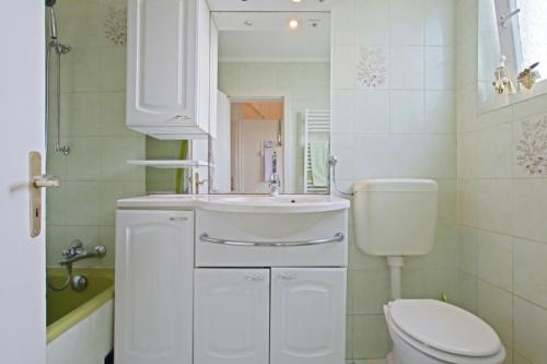 ein weißes Bad mit einem WC und einem Waschbecken in der Unterkunft Private Apartment in Hannover