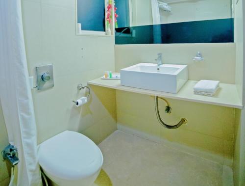 a bathroom with a white sink and a toilet at Hotel Clarks Collection Bhavnagar in Bhavnagar