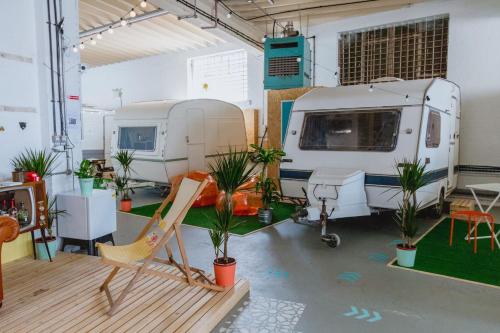 a room with a rv and a chair and plants at Towed Town Camping and Event Space in Bristol