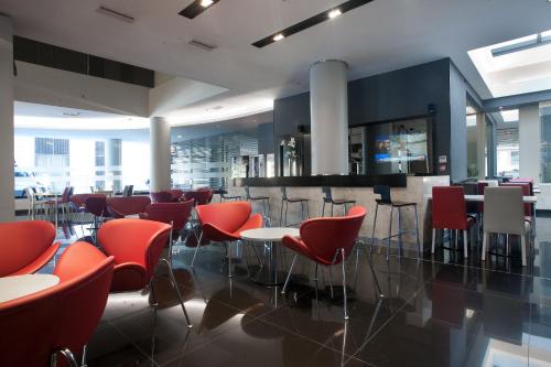 un restaurant avec des chaises et des tables rouges dans un bâtiment dans l'établissement Two Hotel Buenos Aires, à Buenos Aires