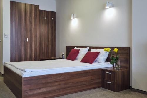 a bedroom with a large bed with white sheets and red pillows at Boca Boutique Hotel in Timişoara