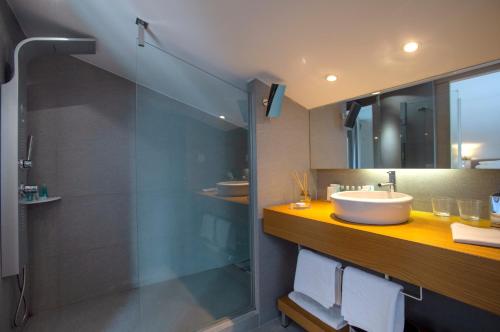 a bathroom with a sink and a glass shower at Tiamo Secrets - Palm Garden in Vourvourou