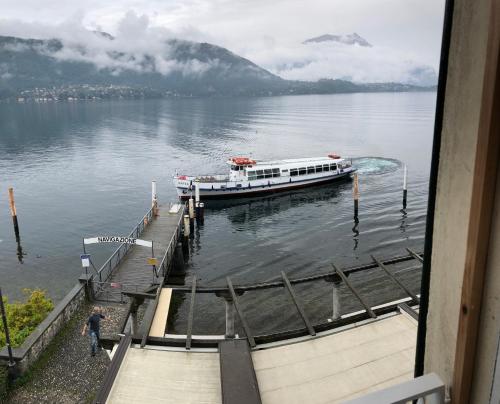 a boat is docked at a dock on a lake at A Dream On The Lake in Lierna