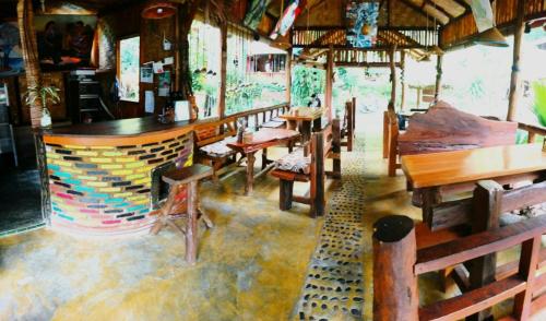 ein Restaurant mit Holztischen und -stühlen in einem Zimmer in der Unterkunft Eriono guest house Bukit lawang in Bukit Lawang