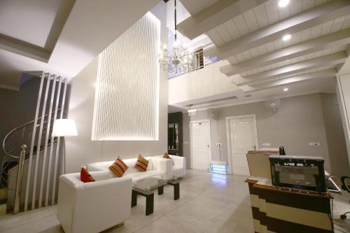 un soggiorno con mobili bianchi e lampadario pendente di Hotel Diamond Plaza a Chandīgarh