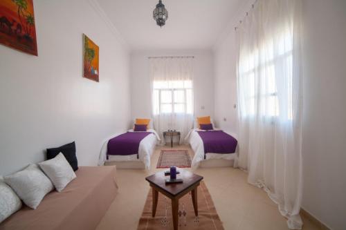 - un salon avec deux lits et un canapé dans l'établissement Bio Beldi HOME, à Tafraout