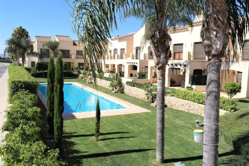 an apartment complex with a swimming pool and palm trees at Townhouse overlooking the pool in San Javier