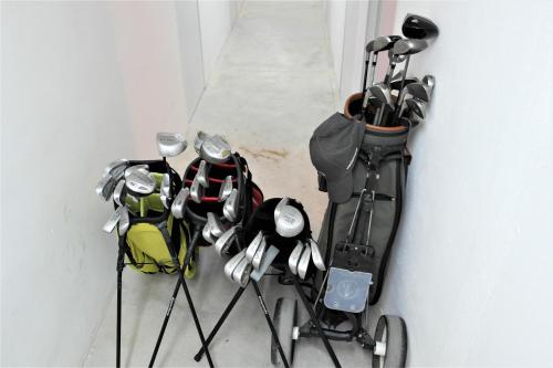 a group of golf clubs on sticks next to a wall at Townhouse overlooking the pool in San Javier