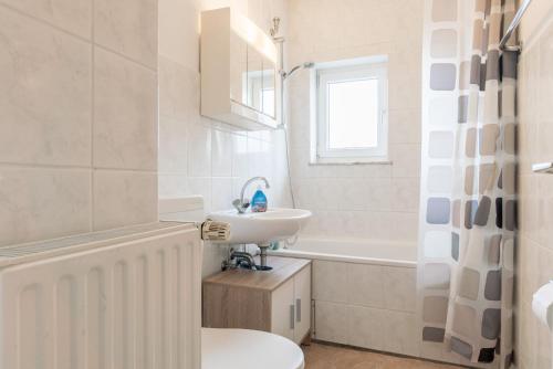 ein Badezimmer mit Waschbecken, Toilette und Badewanne in der Unterkunft Private Apartment in Hannover