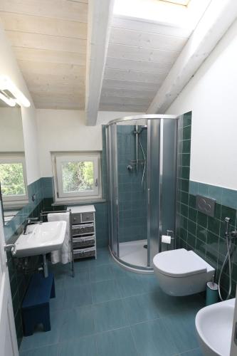 a bathroom with a shower and two sinks and a toilet at Casa delle Rocche in Monteu Roero