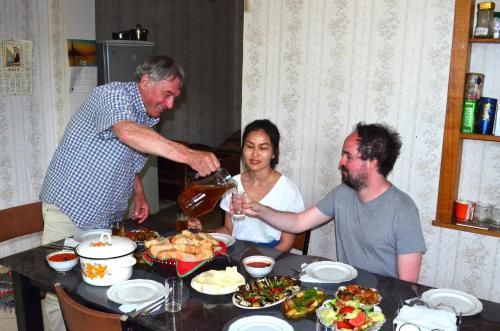 a group of people sitting around a table with food at Robinson Crusoe in Lagodekhi
