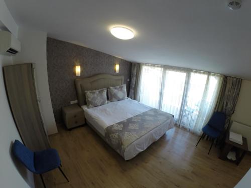 a bedroom with a bed and two blue chairs at Meydan Suites in Istanbul