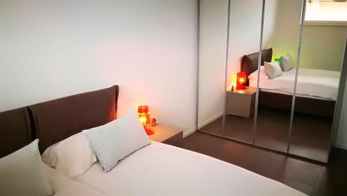 a bedroom with a white bed and a mirror at Suite Laura - Torri del Benaco in Torri del Benaco