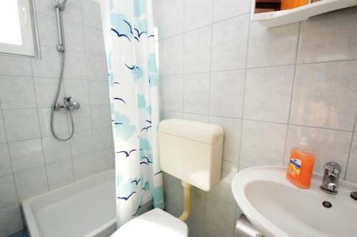 a bathroom with a toilet and a shower and a sink at Apartments Dario in Rovanjska
