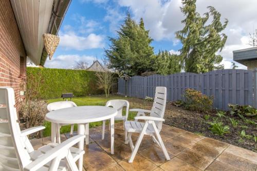 a white table and chairs on a patio at Private Rooms in Gestorf