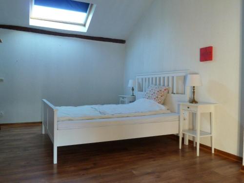 ein Schlafzimmer mit einem weißen Bett und einem Tisch in der Unterkunft Longère en Sologne 2 in La Boullaye