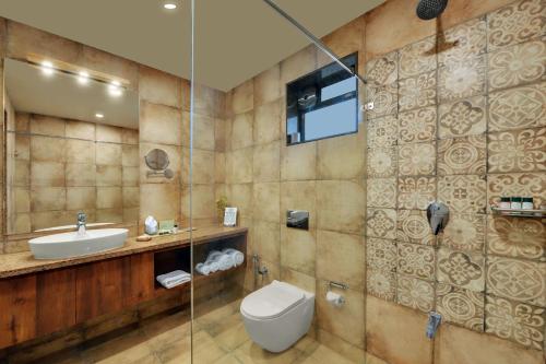 a bathroom with a toilet and a sink at The Fern Sattva Resort - Polo Forest in Vijayanagar