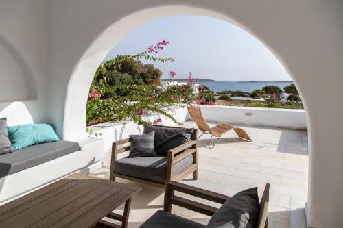 un patio con sillas y mesas y vistas al océano en The Sand Collection Villas, en Santa Maria