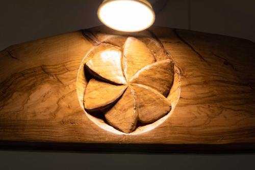 a light on a wooden table with a leaf on it at B&B La Stradella in Ostuni