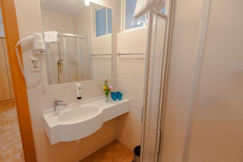 a bathroom with a sink and a mirror at Pension Leuprecht in Reutte