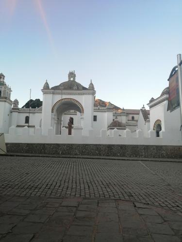 a white building with an arch in a courtyard at Hostal Puerto Alegre in Copacabana