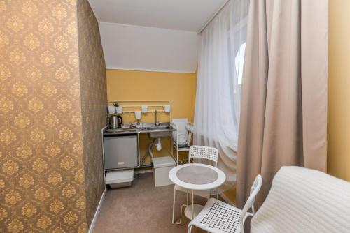 ein kleines Zimmer mit einer Küche sowie einem Tisch und Stühlen in der Unterkunft Apartamentai Birštono centre su židiniu in Birštonas