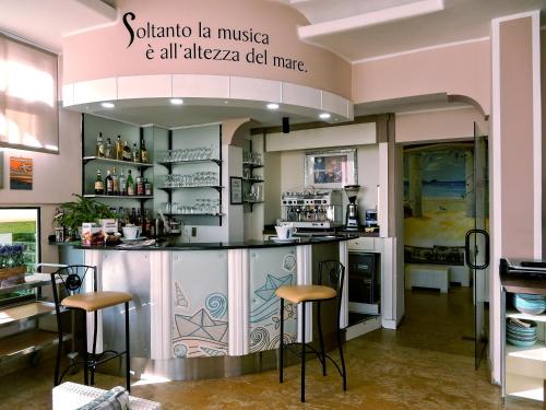 a kitchen with a counter and stools in a room at Hotel Delfino in Laigueglia