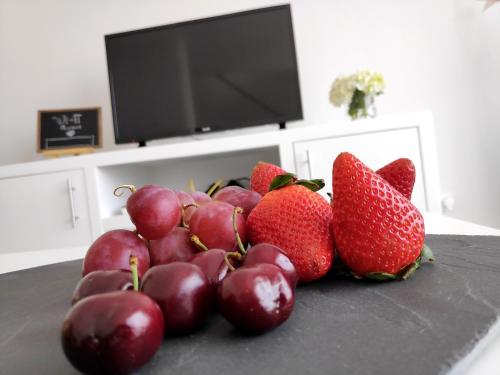 a pile of strawberries and grapes on a table at House Seven in Horta