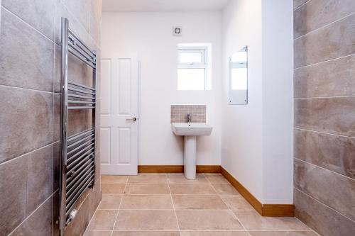 a bathroom with a sink and a toilet at Birch – Three Tuns Apartments in Pettistree