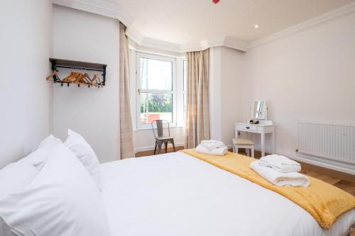 a white bedroom with a large bed and a window at Birch – Three Tuns Apartments in Pettistree