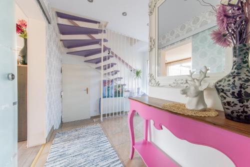 ハノーファーにあるPrivate Houseのピンクのテーブルと鏡が備わる部屋