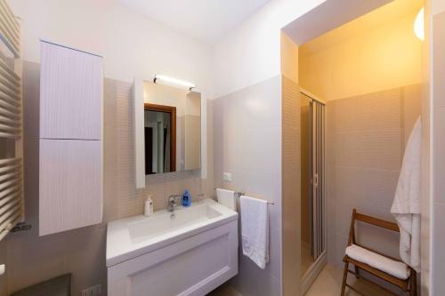 a white bathroom with a sink and a mirror at B&B La Stradella in Ostuni