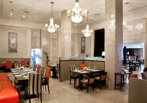 un restaurante con mesas y sillas y un bar en Savoy Hotel en Buenos Aires