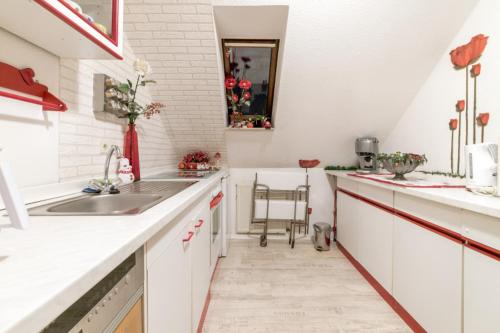 una cocina con armarios blancos y fregadero en Smoker Private Apartment en Hannover