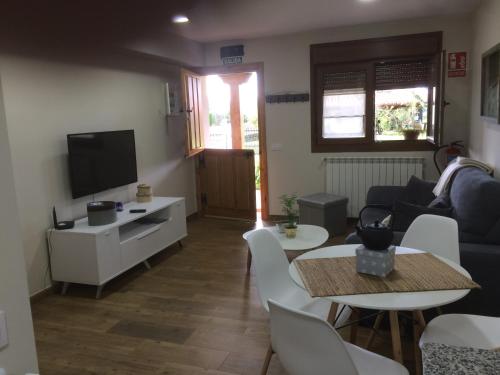 a living room with a couch and a tv at La Llastra de Garaña in Llanes