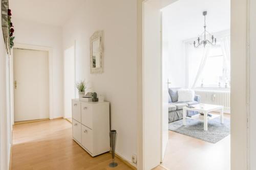 ein weißes Wohnzimmer mit einem Kühlschrank und einem Sofa in der Unterkunft Private Apartment in Hannover