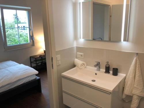 a bathroom with a sink and a mirror and a bed at ennsliving in Enns