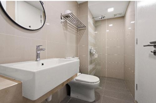 a bathroom with a sink and a toilet and a mirror at Suria North Kiara, Mont Kiara in Kuala Lumpur