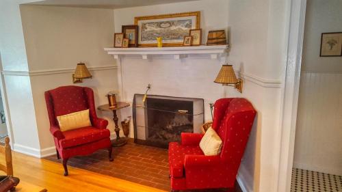 a living room with two chairs and a fireplace at Lilac Inn in Brandon