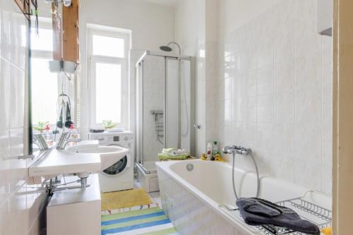 a white bathroom with a tub and a sink at Private Room in Hannover