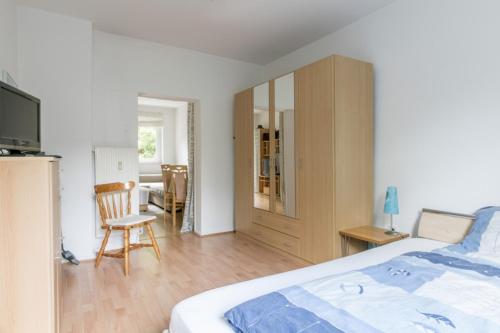 ハノーファーにあるPrivatapartment Messe-Cityのベッドと椅子とテーブルのある寝室