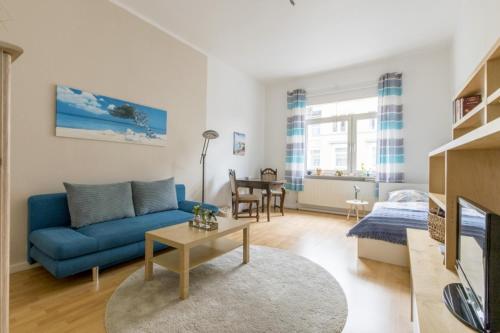 a living room with a blue couch and a table at Private Room in Hannover