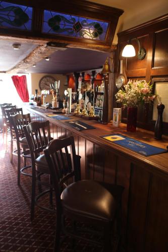 un bar con una fila di sedie in un bar di Red Lion Hotel, Pub & Restaurant a Betchworth