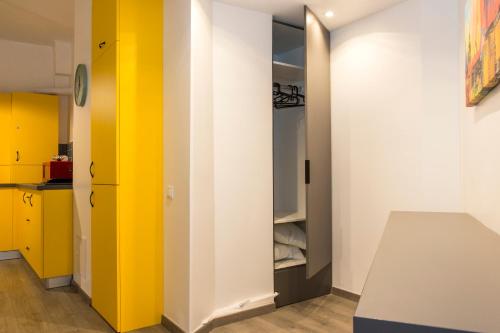 een kamer met gele en witte muren en een keuken bij Premium Apartment by MRG Apartments in Boekarest