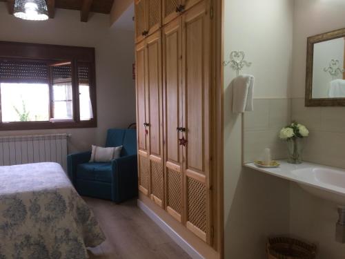 a bedroom with a bed and a tub and a sink at La Llastra de Garaña in Llanes